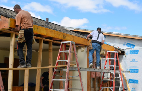 Securing the beam to the old roof trusses.