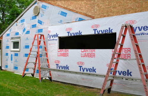Cutting through the Tyvek to reveal the window opening.