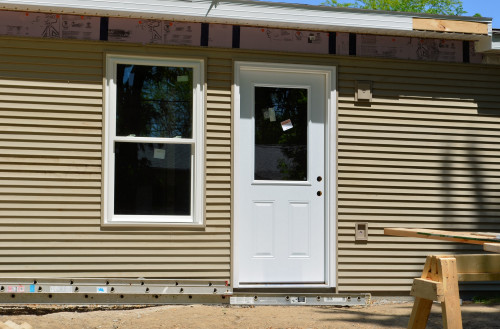 More siding is completed, including fascia for an exterior light and electrical outlet.