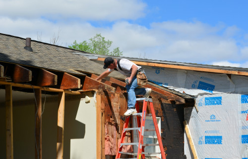 Trimming the old roof trusses in preparation for installing the engineered beams.