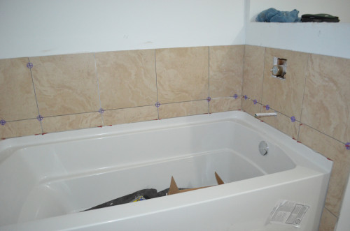The tub area has its tile but awaits grout.